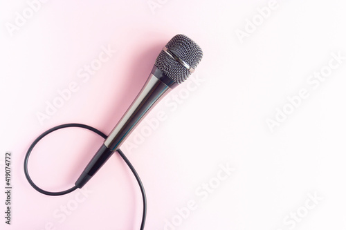 Microphone on a colorful pink background close up. Singing, writing music, karaoke online, creativity, vocals concept, symbol. Singing lessons