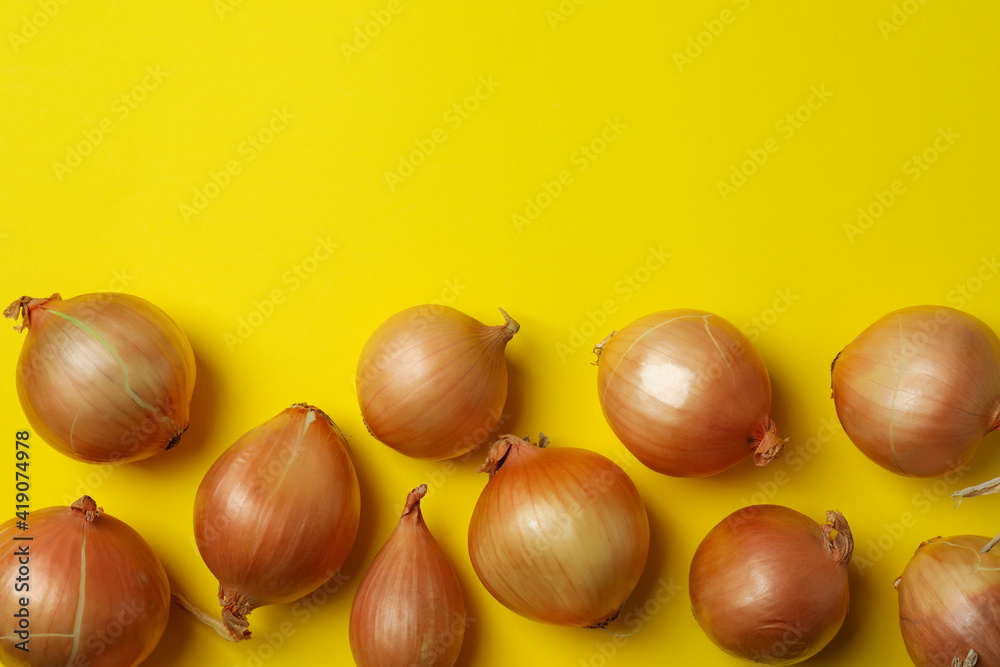Ripe fresh onion on yellow background, space for text Ripe fresh onion on yellow background, space for text