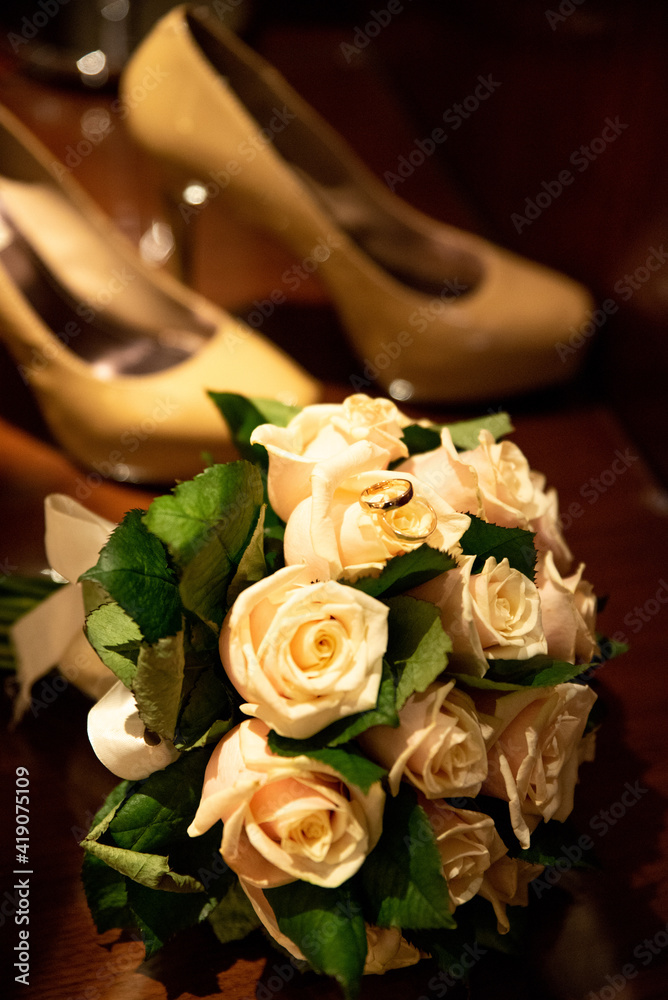 Fototapeta premium Bridal bouquet and brides' shoes in the background