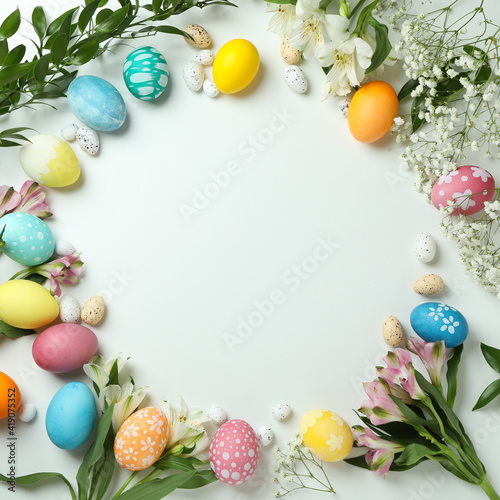 Wall Mural Easter eggs and beautiful flowers on white background, space for text