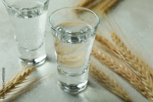 Shots of vodka and spikelets on white textured table