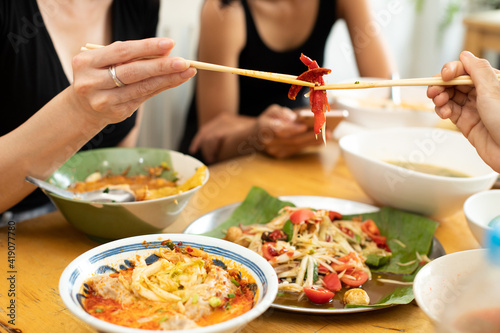 Woman eats Chili spicy and hanging on chopstick to mouth photo