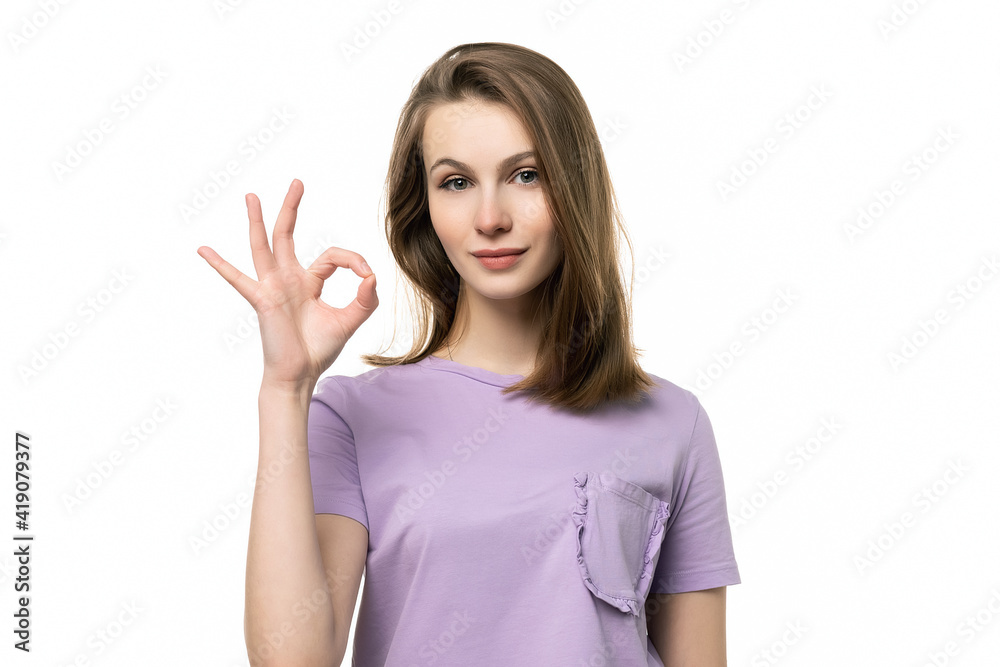 close up portrait of attractive girl in casual t shirt showing OK gesture with hand. Human emotions, gesture concept close up portrait of attractive girl in casual t shirt showing OK gesture with hand. Human emotions, gesture concept
