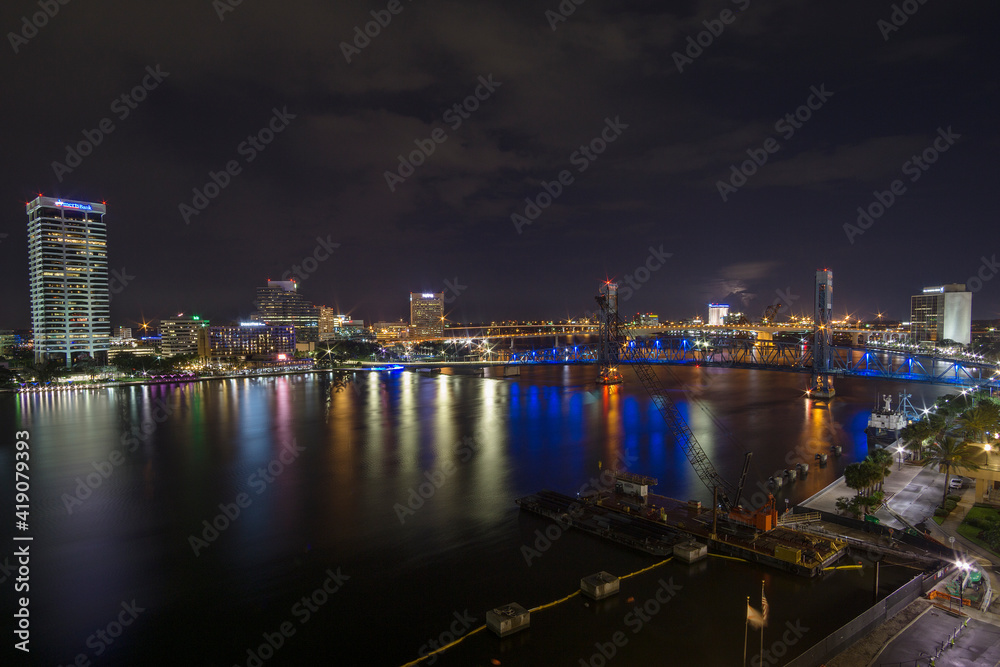 night scene of downtown Jacksonville Florida Landing area beside the St. Johns river showing the Main Street Bridge and large well lit buildings.