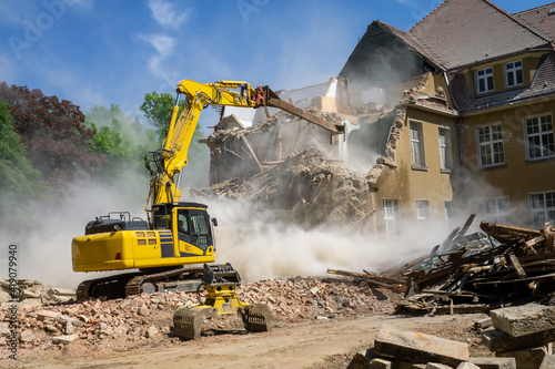 Construction industrial site digger yellow demolishing house for reconstruction photo