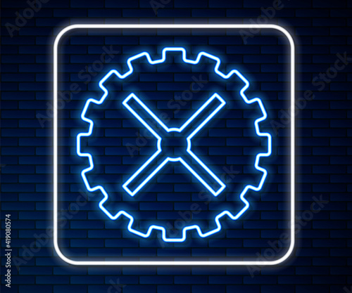Glowing neon line Bicycle sprocket crank icon isolated on brick wall background. Vector.