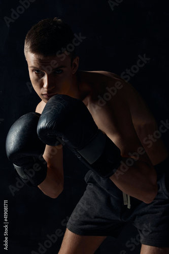 man in boxing gloves on black background workout bodybuilder fitness
