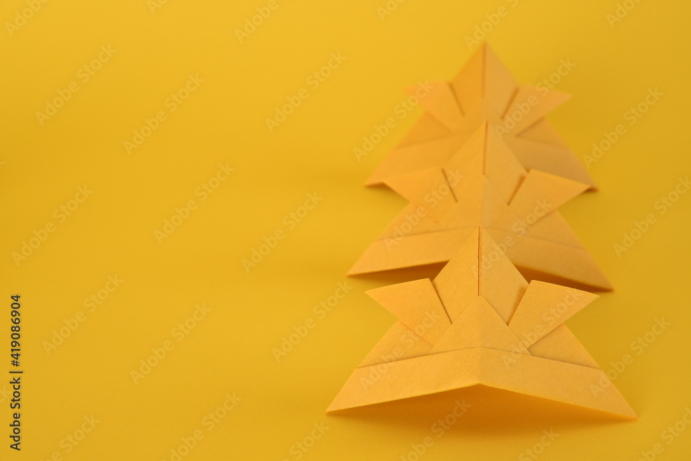 Origami helmet on yellow background.