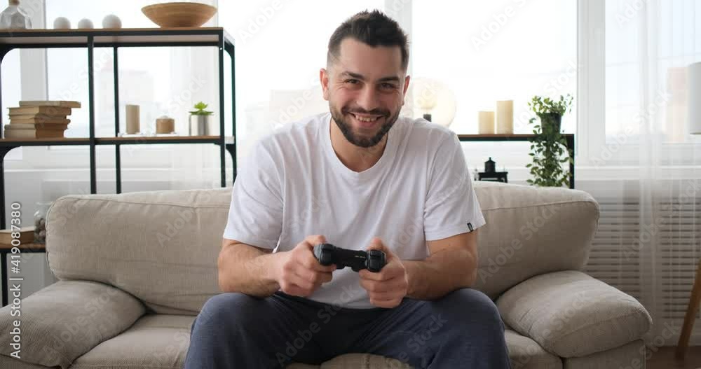 The man plays the TV game on sofa The man plays the TV game on sofa