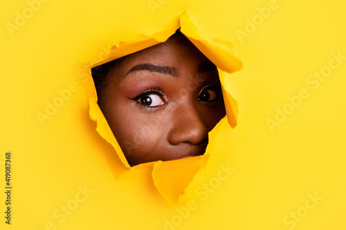 Photo of funny peeking adorable lady eyes curious look camera through bright yellow color background © deagreez