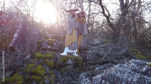 
European man with beard meditates in traditional, Japanese, Shugendo outfit outdoors in nature photo