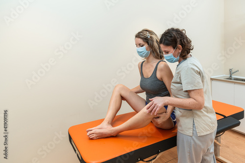 Schilderij op canvas Physiotherapist and patient in Global Postural Re-education session, with pandemic protection mask