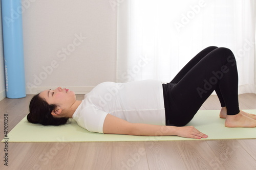 A young pregnant woman is doing fitness at home. .It is important to exercise during pregnancy.
