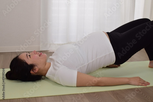 A young pregnant woman is doing fitness at home. .It is important to exercise during pregnancy.