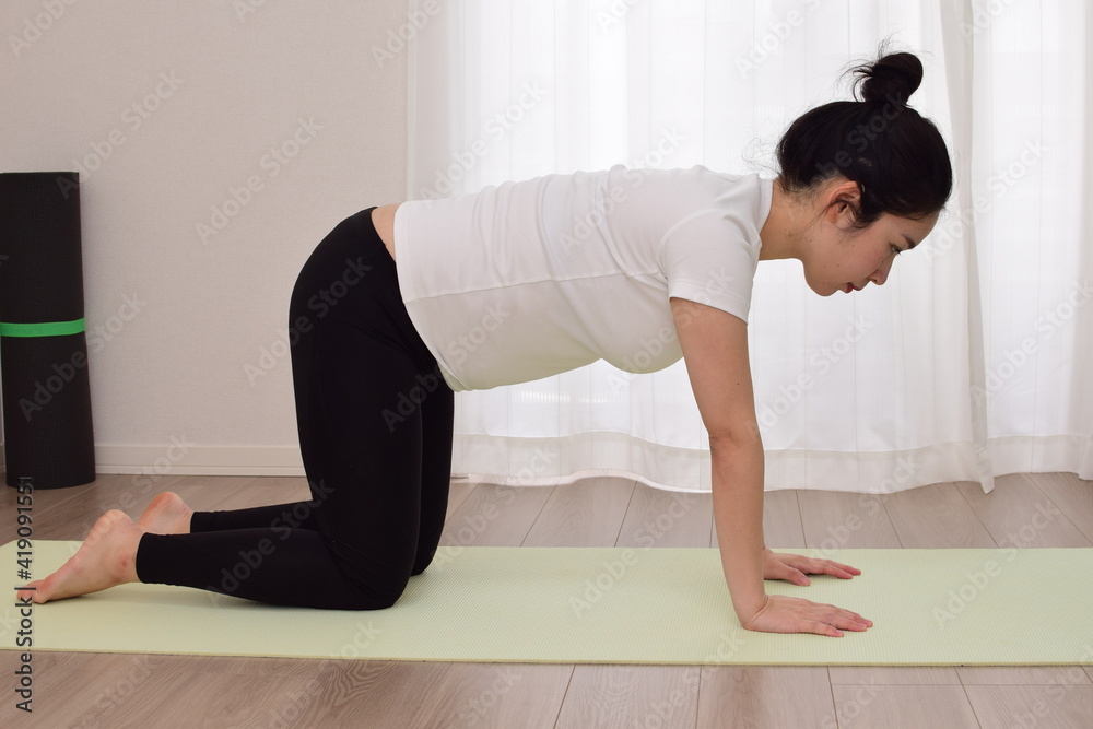 A young pregnant woman is doing fitness at home. It is important to exercise during pregnancy.