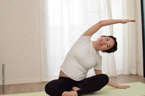 A young pregnant woman is doing fitness at home. It is important to exercise during pregnancy.
