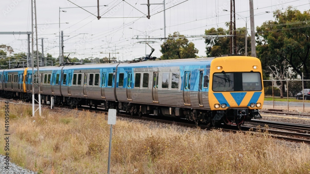 Fototapeta premium Commuter train approaching a train station in Melbourne Victoria Australia