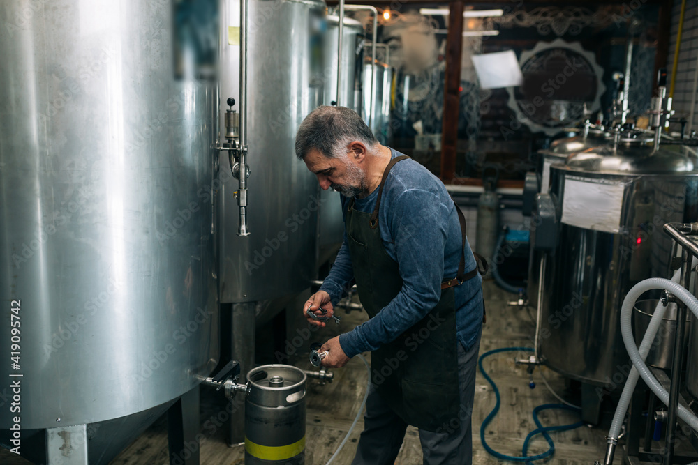 brewer working in his mini craft brewery brewer working in his mini craft brewery