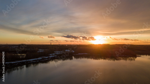 Aerial view of a beautiful and dramatic sunset over a forest lake reflected in the water  landscape drone shot. Blakheide  Beerse  Belgium. High quality photo