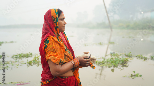 Woman worshipping to sun during chhath puja photo