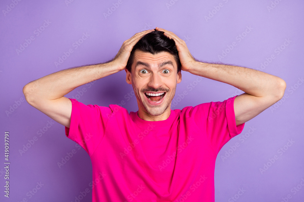 Photo of young happy excited crazy amazed surprised man hold hands on head see big sale discount isolated on violet color background Photo of young happy excited crazy amazed surprised man hold hands on head see big sale discount isolated on violet color background