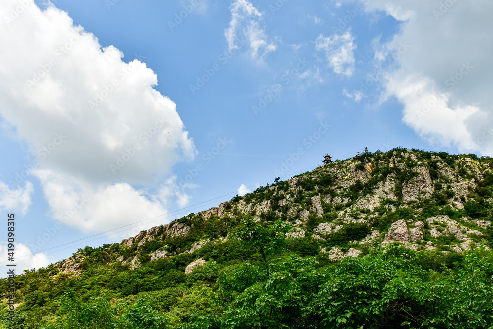 Peaks and forest landscape in the background of blue sky and white clouds. Photographed in Dagushan, Dandong, Liaoning, China