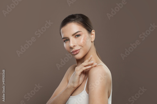 Healthy model woman with clear skin on brown background. Facial treatment, cosmetology and skin care concept