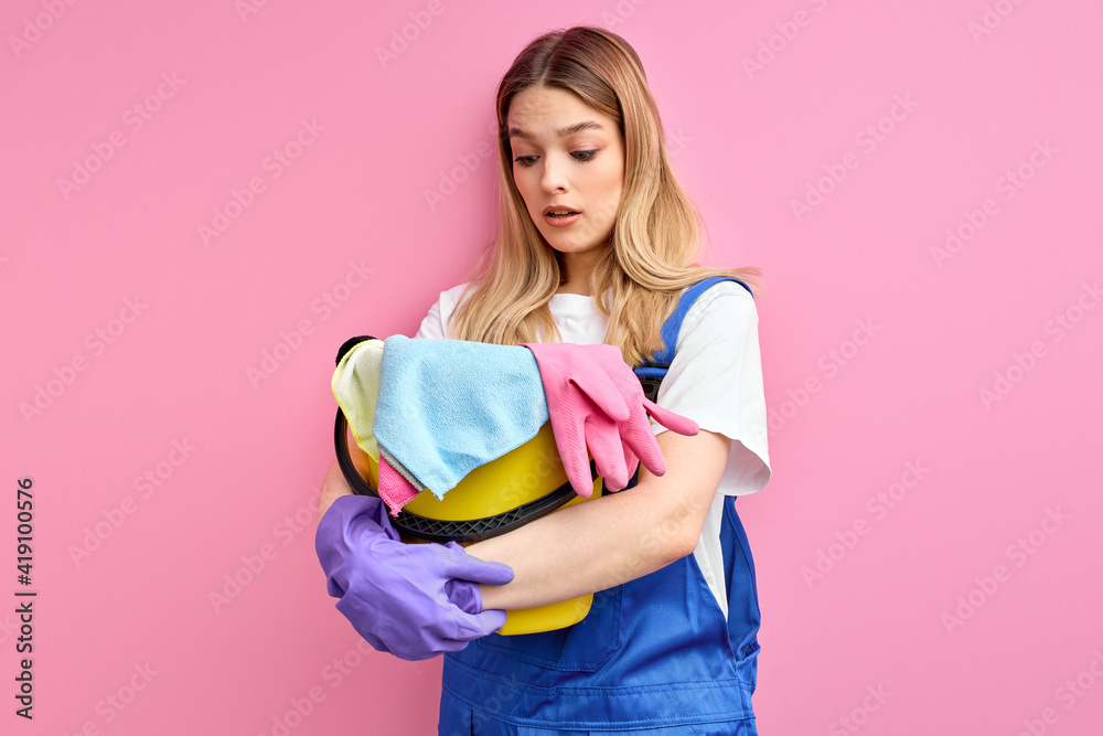 frightened woman with bucket and rags stands, young caucasian female
