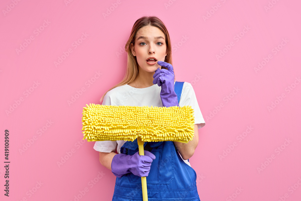 Cleaner woman wearing gloves holding mop over isolated pink background serious face thinking about question, very confused idea. portrait Cleaner woman wearing gloves holding mop over isolated pink background serious face thinking about question, very confused idea. portrait