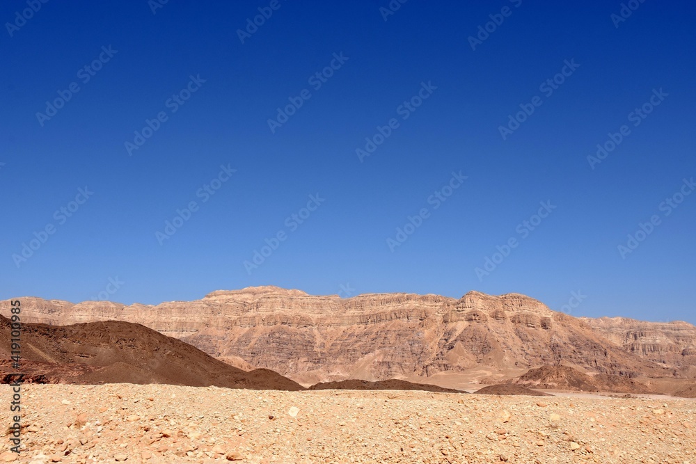 Desert landscape of Negev desert in Timna Park, Israel. The brownish colors and shades of rocks contrast with clear blue sky. There is a lot of copy space. Desert landscape of Negev desert in Timna Park, Israel. The brownish colors and shades of rocks contrast with clear blue sky. There is a lot of copy space.
