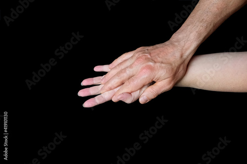 male and female hands together on black background, old skin with wrinkles and veins, concept of health, age-related changes, love, tender relationship of a couple in love, isolated image