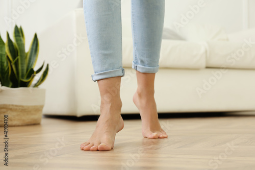 Woman walking barefoot at home, closeup. Floor heating concept