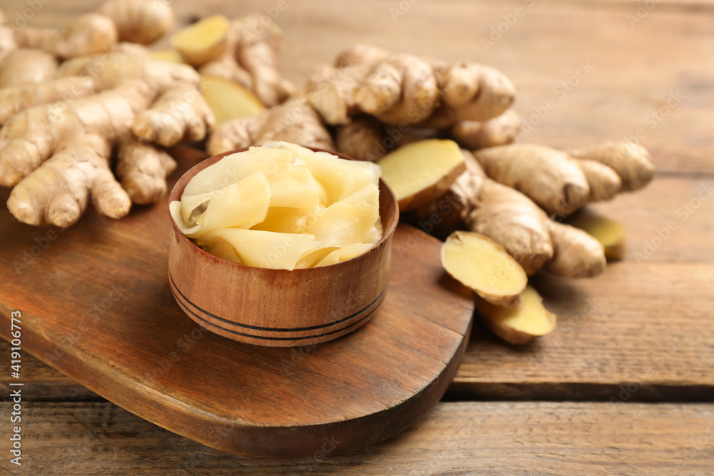 Spicy pickled ginger and root on wooden table, space for text Spicy pickled ginger and root on wooden table, space for text