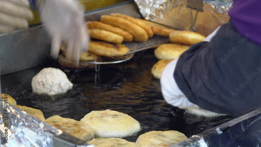 Frying Filled Dough In A Griddle With Oil. Cooking Hotteok, Korean Pancake, And Popular Street Food In South Korea. close up Frying Filled Dough In A Griddle With Oil. Cooking Hotteok, Korean Pancake, And Popular Street Food In South Korea. close up