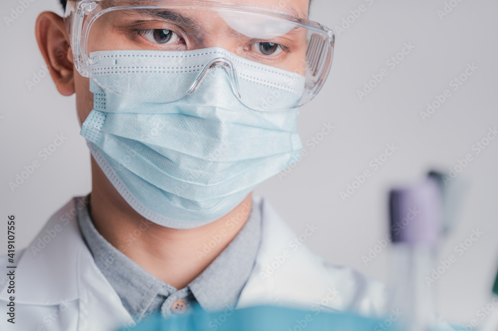 Doctors wear a surgical mask and glasses, Scientists, Scientists hold syringes and vaccines for COVID-19., vaccination and laboratory experiments. Virus protection concept COVID-19, Doctors wear a surgical mask and glasses, Scientists, Scientists hold syringes and vaccines for COVID-19., vaccination and laboratory experiments. Virus protection concept COVID-19,