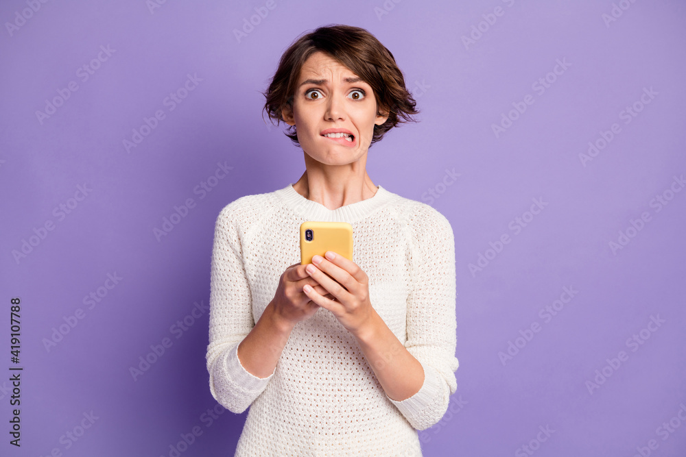 Photo portrait of nervous troubled female influencer reading fake information isolated on bright violet color background Photo portrait of nervous troubled female influencer reading fake information isolated on bright violet color background