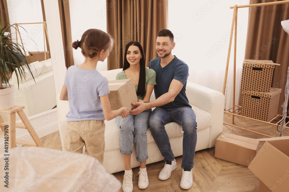 Daughter giving moving box to her parents in new house Daughter giving moving box to her parents in new house