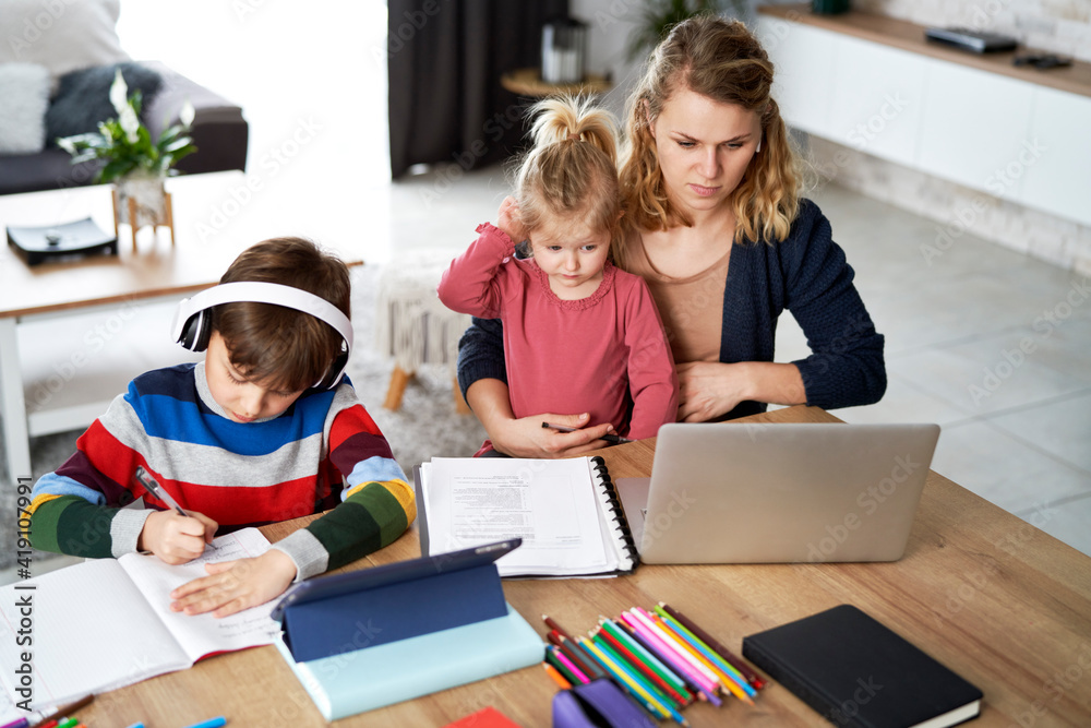 Mother working from home with young children in quarantine isolation Mother working from home with young children in quarantine isolation