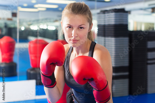 Portrait of young woman who is boxing in gym © JackF