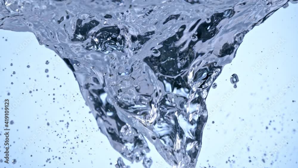 Super Slow Motion Shot of Water Whirl on Light Blue Background at 1000fps.