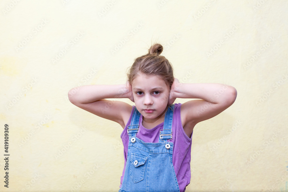 Frightened pre-teen girl closed her ears with her hands Frightened pre-teen girl closed her ears with her hands