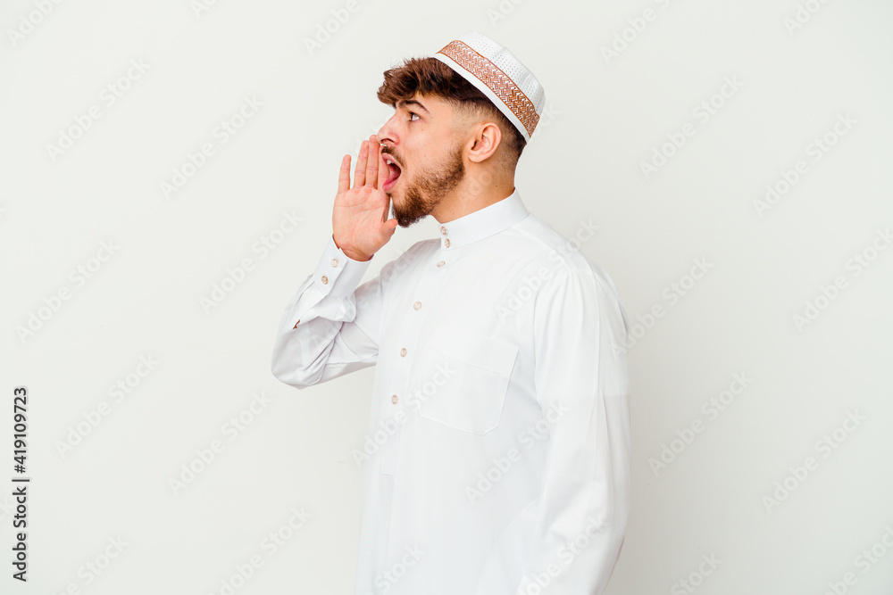 Young Arab man wearing the typical arabic costume isolated on white background shouting and holding palm near opened mouth. Young Arab man wearing the typical arabic costume isolated on white background shouting and holding palm near opened mouth.