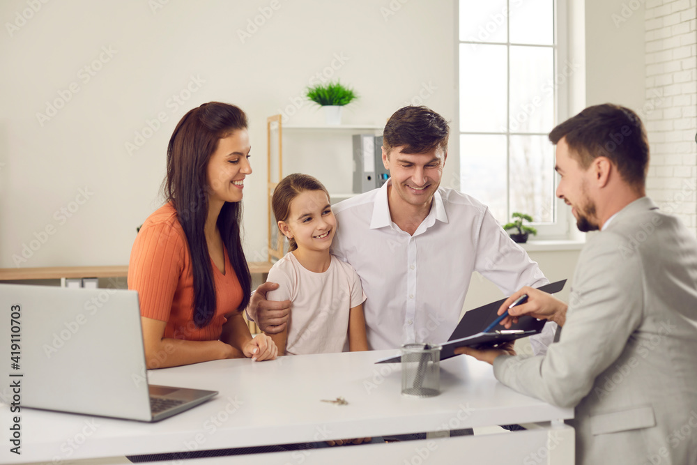 Happy family with daughter sitting and looking at contract points in hands of real estate agent feeling happy and positive with making deal about relocating. Renting buying moving to new accomodation Happy family with daughter sitting and looking at contract points in hands of real estate agent feeling happy and positive with making deal about relocating. Renting buying moving to new accomodation