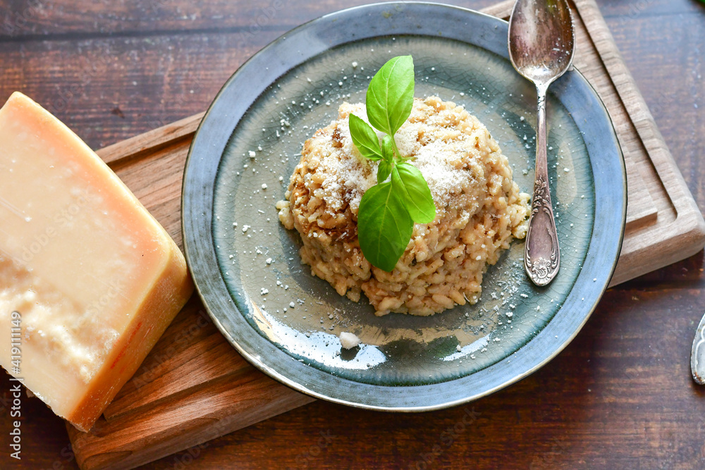 Italian home made creamy mushroom risotto with parmesan cheese and fresh basil on rustic background Italian home made creamy mushroom risotto with parmesan cheese and fresh basil on rustic background