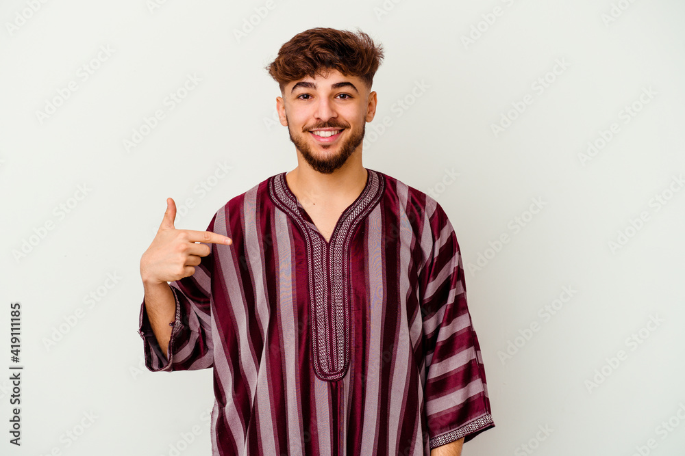 Naklejka premium Young Moroccan man isolated on white background person pointing by hand to a shirt copy space, proud and confident