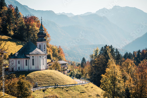 Incredible Autumn landscape. Scenic view on Maria Gern church with mountains on background. Vivid atmospheric nature scenery. Natural background. Popular travel destination photo