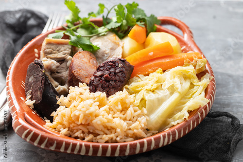 typical portuguese dish boiled meat, smoked sausages and vegetables on ceramic dish photo