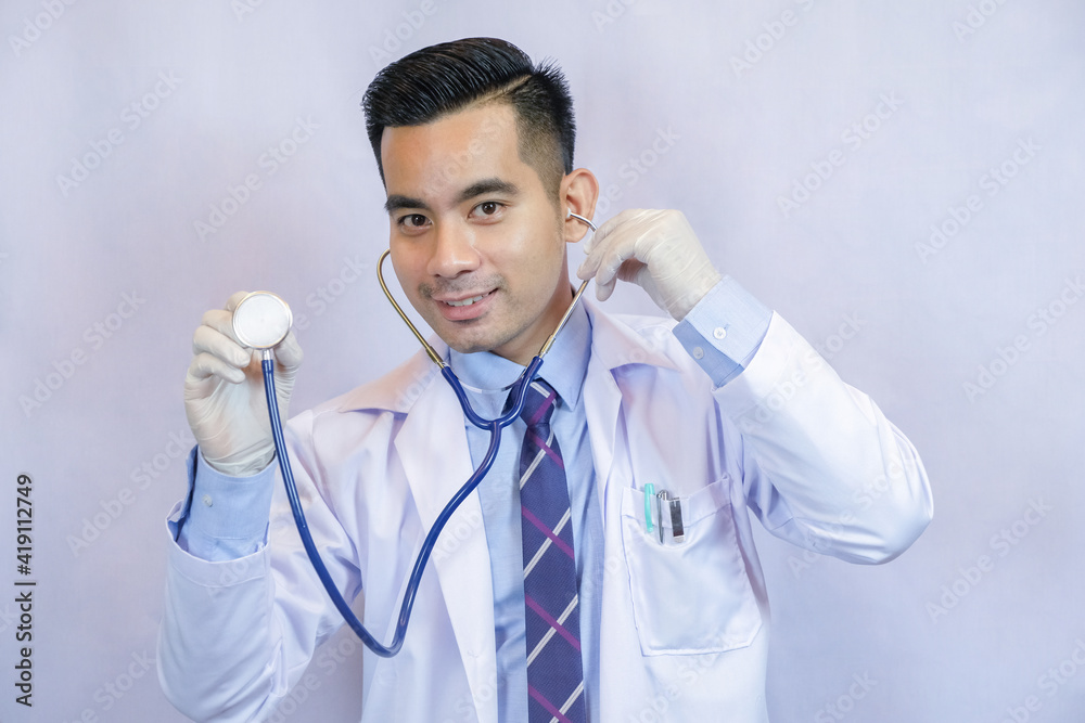 Portrait of confident young medical doctor on black background. He using stethoscope. Portrait of confident young medical doctor on black background. He using stethoscope.