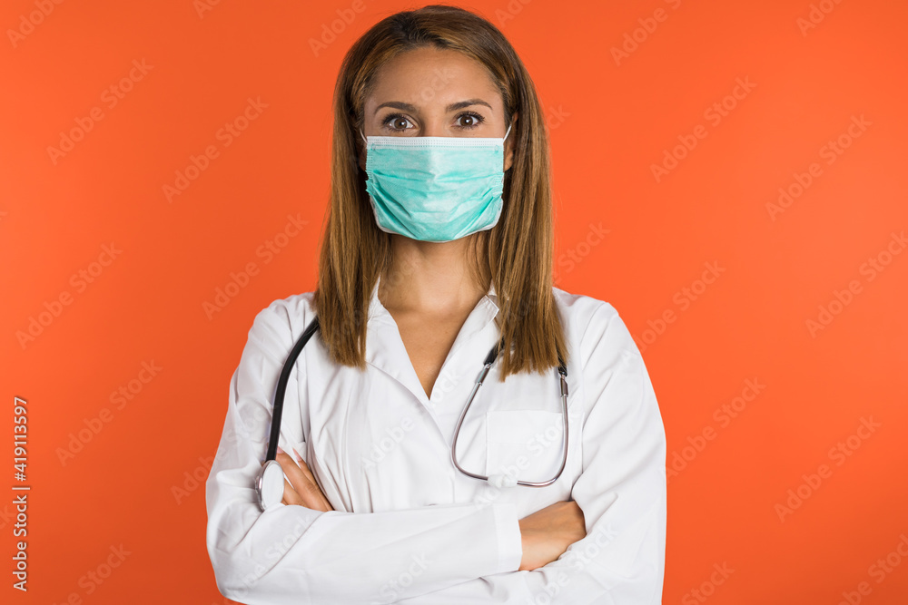 Women doctor with face mask smiles in front of the camera. Women doctor with face mask smiles in front of the camera.