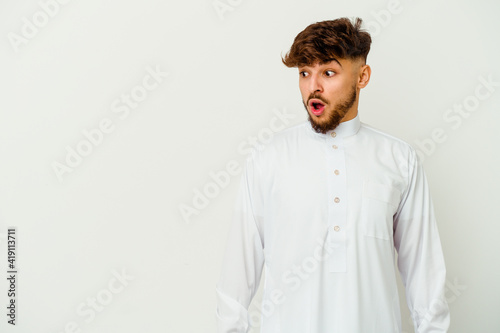 Young Moroccan man wearing a typical arab clothes isolated on white background being shocked because of something she has seen.